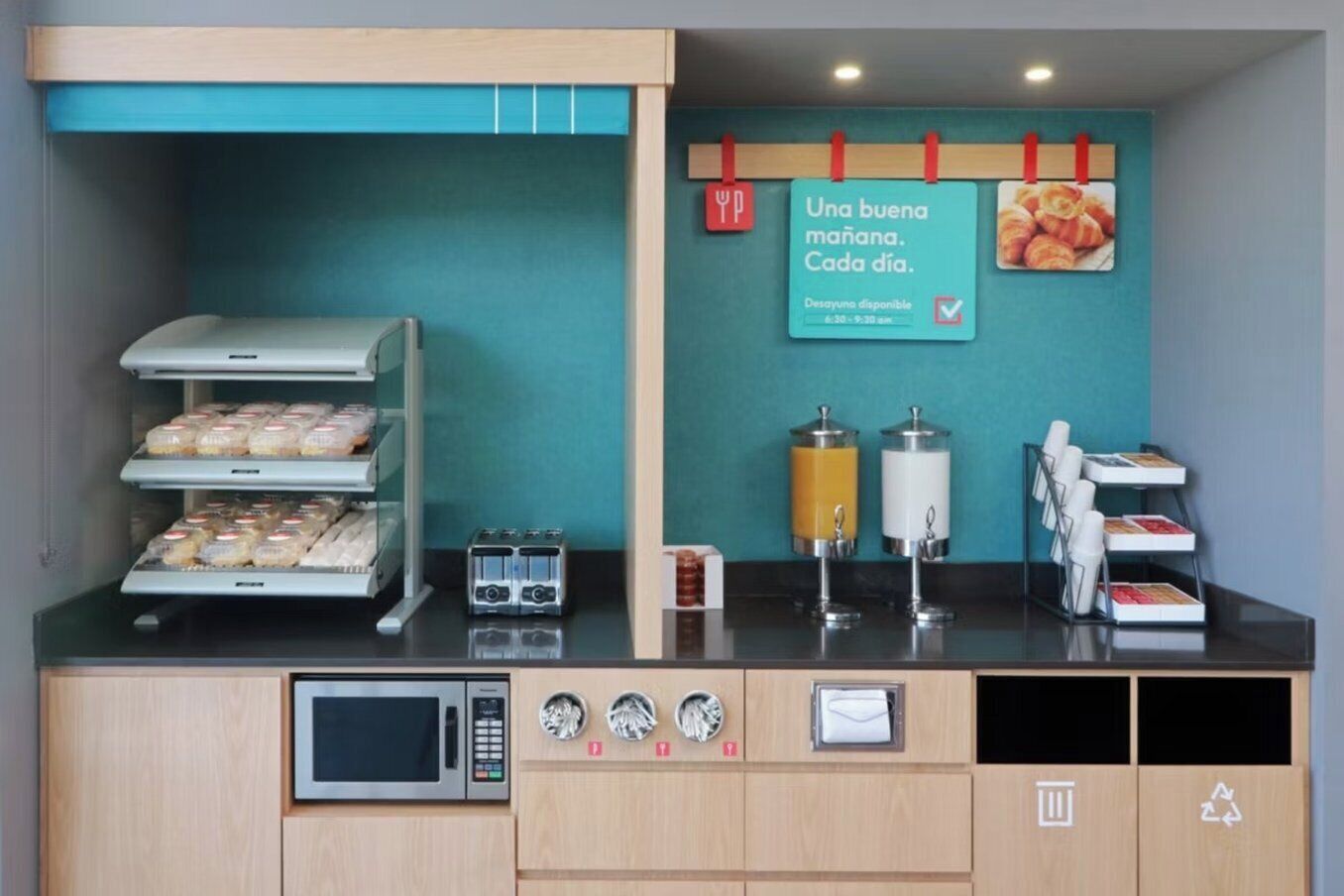 Estación de desayuno con microondas, tostadora y dispensadores de café.
