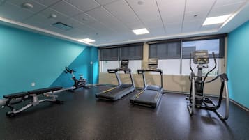 A gym with treadmills, a bench, and exercise equipment.