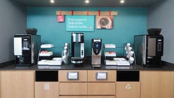 A coffee station with four coffee machines and a sign above them.