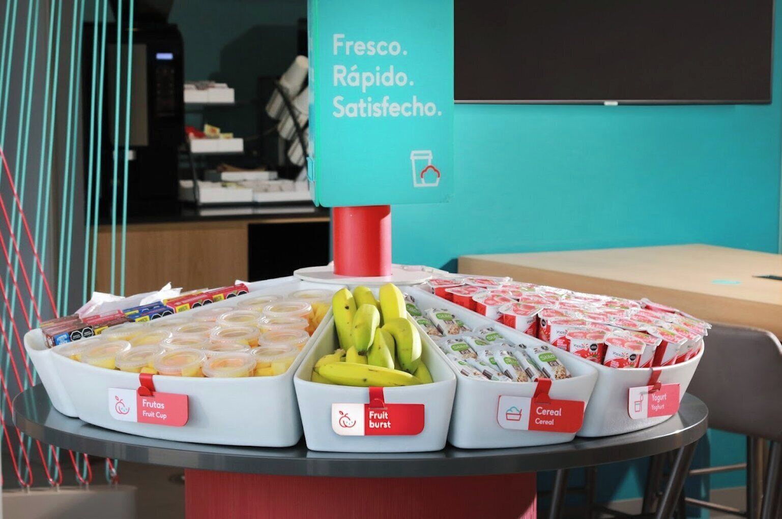 Ein Tisch mit beschrifteten Behältern voller Obst, Früchten und Getreide.