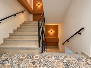 A staircase with a handrail on both sides, leading to an upper floor. - Apartasuites ISABEL (Cali)