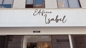 A building with a sign reading "Edificio Isabel" and a door with a sign "Carrera 19 No. 4A-20". - Apartasuites ISABEL (Cali)