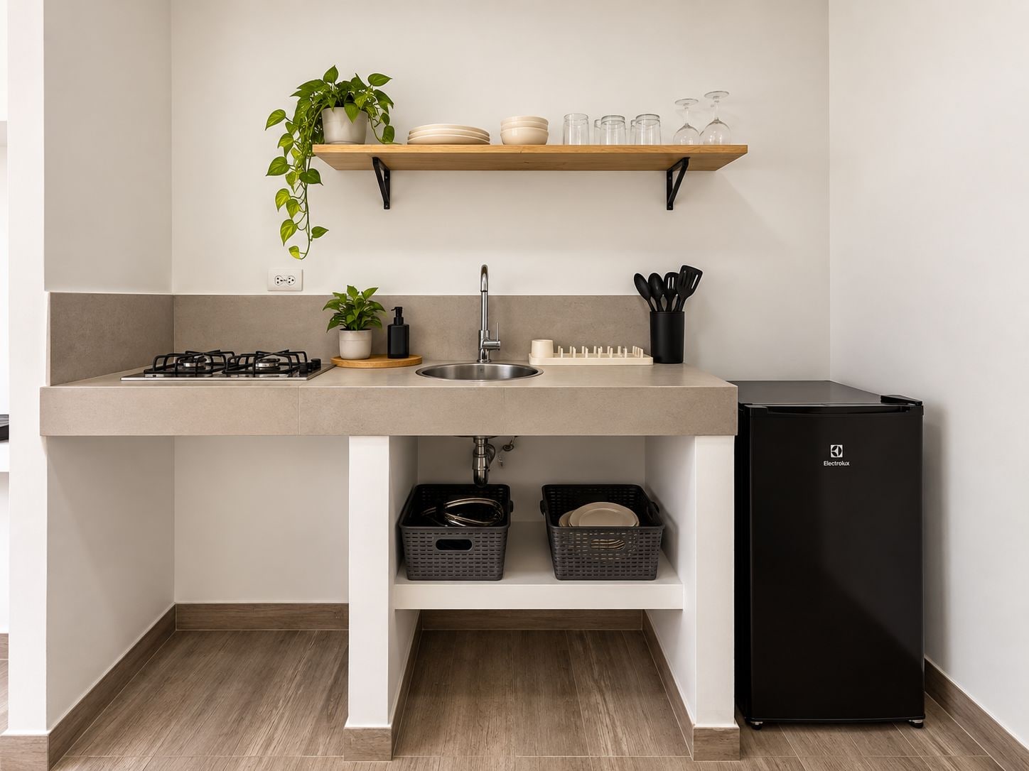 A modern kitchen with a built-in gas stove, a stainless steel sink, a black refrigerator, and a shelf with dishes and a plant.