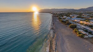 A coastal town with a beach, houses, and a clear view of the sea during sunset. - Votsalo Ierapetra (Ierapetra)