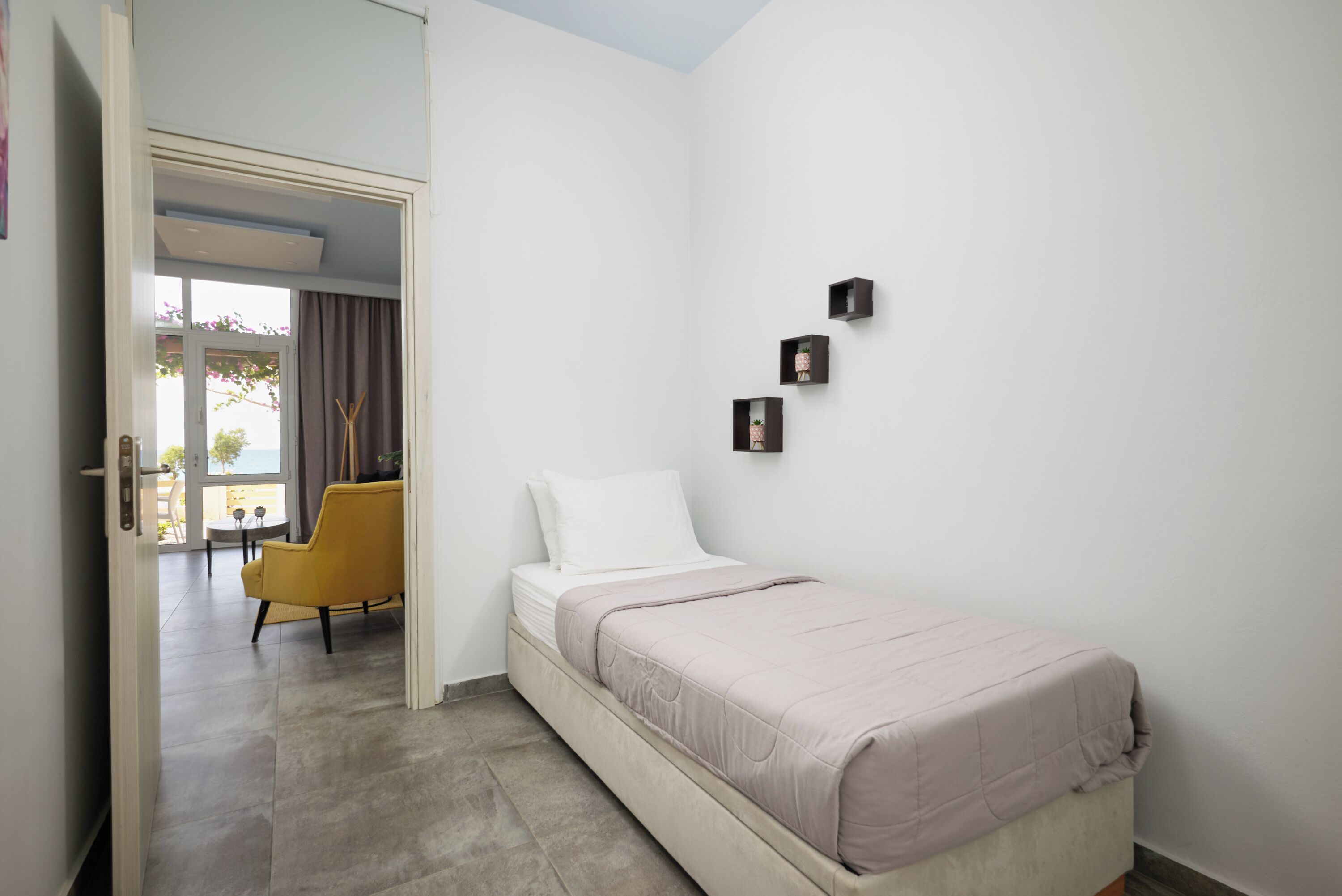 Un dormitorio con una cama, una silla y una mesita.