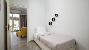 Un dormitorio con una cama, una silla y una mesita.