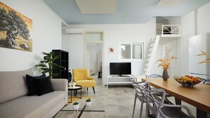 A modern living room with a sofa, coffee table, and a dining area with chairs and a table. - Votsalo Ierapetra (Ierapetra)