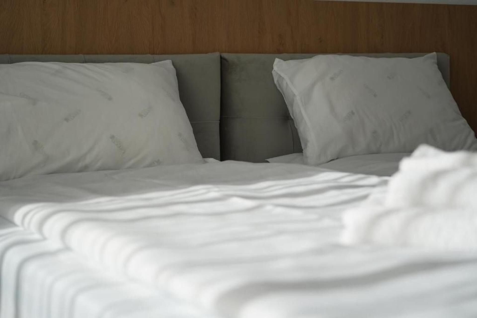 A bed with white bedding and two pillows.
