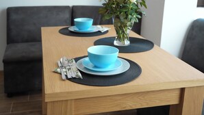 A dining table with two blue bowls and a vase of white flowers. - 2 Bed Apt - Sleeps 4, Terrace & Pet Friendly (Sandanski)