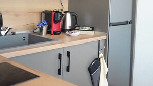 A compact kitchen with grey cabinets, a wooden countertop, a kettle, a toaster, and a refrigerator. - 2 Bed Apt - Sleeps 4, Terrace & Pet Friendly (Sandanski)