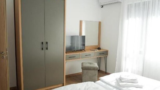 A bedroom with a wardrobe, a desk with a mirror, a television, and a bed with neatly folded white linens. - 2 Bed Apt - Sleeps 4, Terrace & Pet Friendly (Sandanski)