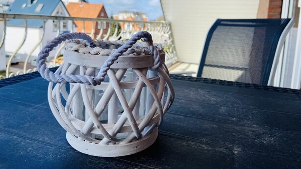 A white lantern with a rope handle on a dark blue table. - House Nicole vacation apartment 5 (Cuxhaven)