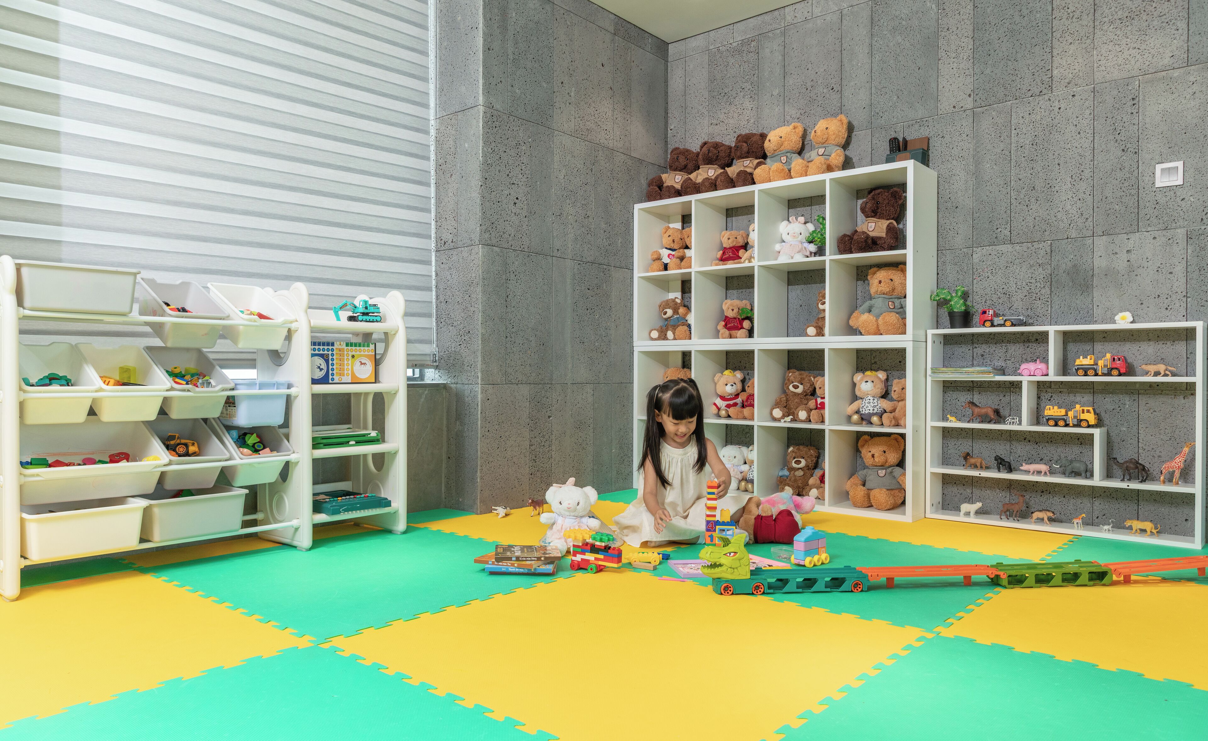 A playroom with storage shelves and a child playing with toys.