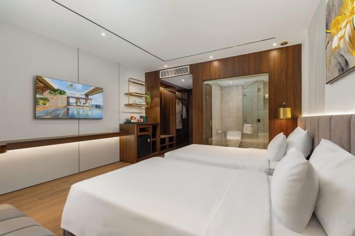 Een moderne hotelkamer met een groot bed, een bureau en een badkamer.