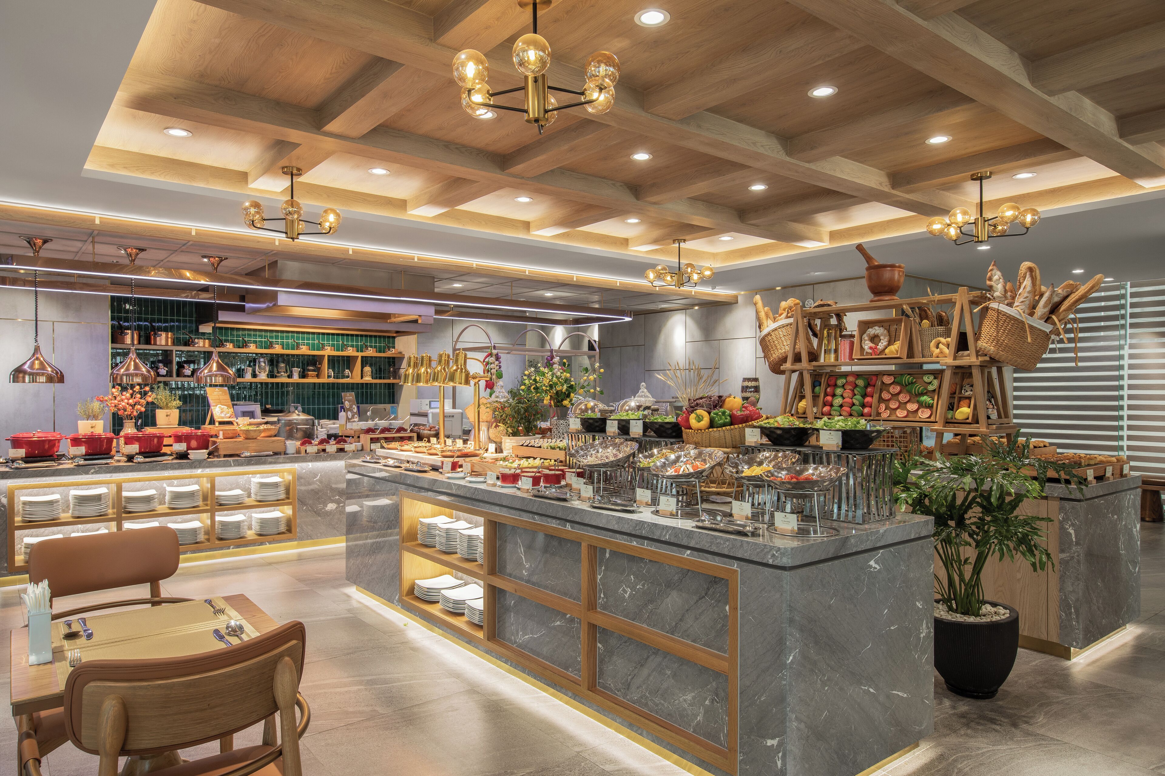 A modern restaurant with a marble counter, wooden ceiling, and various food displays.