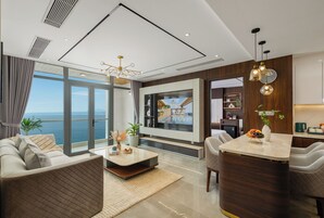 Luxury Room, Ocean View | Living area | 65-inch LCD TV with satellite channels