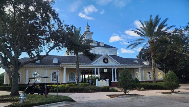 A building with a central entrance, columns, and a clock.