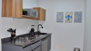 A compact kitchen with a gas stove, sink, and modern cabinetry. - Céntrico y Confortable Departamento 101 (San Luis Potosí)