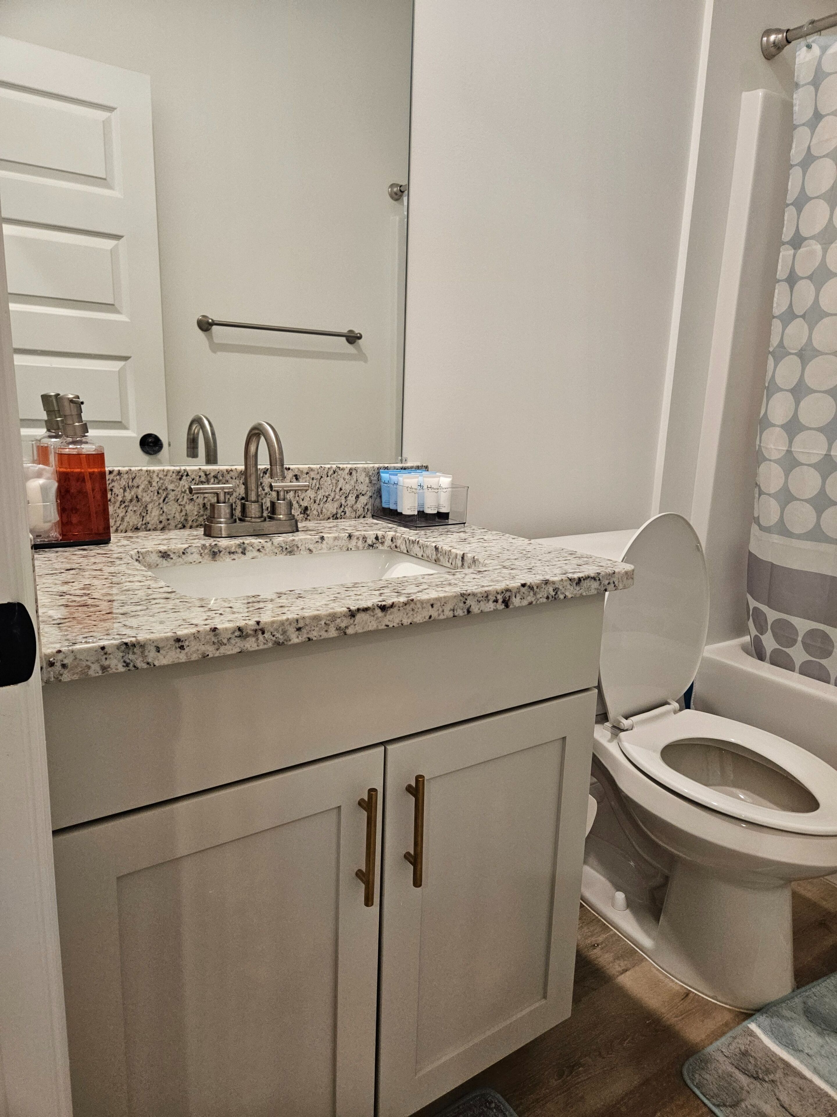 Ein Badezimmer mit Marmorplatte, Toilette und Waschbecken mit Handtuchhalter darüber.