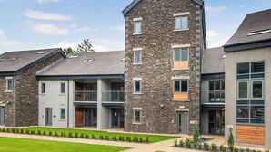 A modern multi-story building with stone facade, large windows, and a flat roof. - 1 bedroom accommodation in Ulverston (Ulverston)