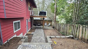 A red building with a brick pathway leading to a wooden deck. - Private guest suite with Full kitchen & laundry (Kirkland)