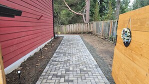 A brick pathway leading to a wooden fence. - Private guest suite with Full kitchen & laundry (Kirkland)