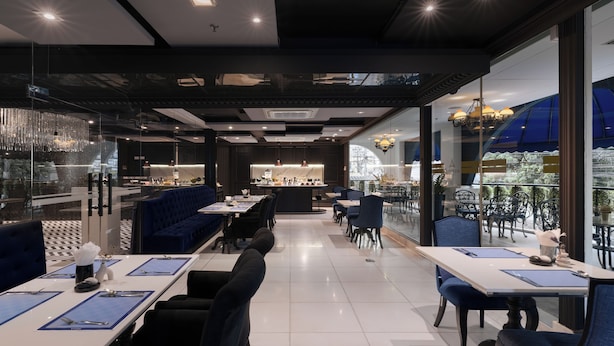 Un restaurante moderno con zona de bar, asientos y vistas amplias a través de grandes ventanales.