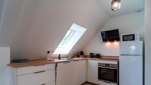 A modern kitchen with a skylight, a microwave, a refrigerator, and an oven. - Le Haut du Nelud - Appt dans maison avec jardin (Locmariaquer)