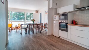 Eine moderne Küche mit weißen Schränken, einem eingebauten Ofen und einem großen Fenster.