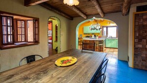 Un coin repas avec une table en bois, des chaises et une assiette jaune.