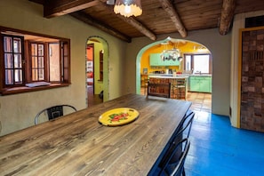 Un comedor con una mesa de madera, sillas y un plato amarillo.