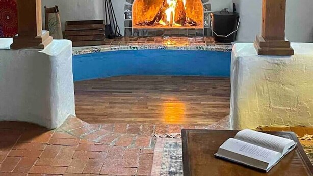 Une pièce avec une cheminée, une piscine et un livre sur une table.
