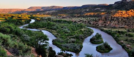 A river winding through a green landscape with hills in the background.