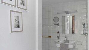 Une salle de bain équipée d’un lavabo, d’un miroir et d’un porte-serviettes.