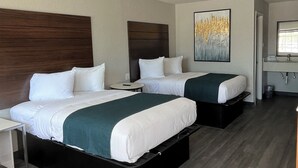 Een hotelkamer met twee bedden, een klein nachtkastje, een spiegel en een schilderij aan de muur.