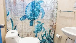 A bathroom with a map-themed wall, a toilet, and a sink. - Studio 4 Casiguaya (Vieques)