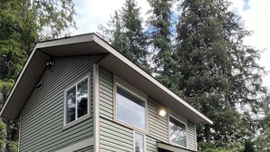 A two-story house with a front porch and a small deck. - Tiny Retreat at Stoney Creek  (Seward)