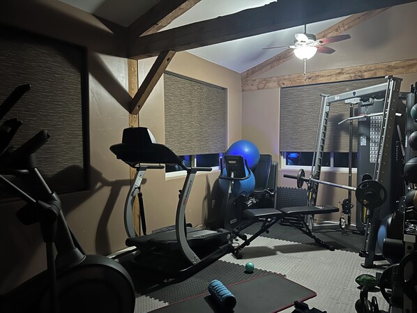 Stay fit on the go with a fully equipped home gym featuring a treadmill, stationary bike, and free weights.