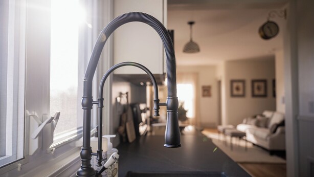 A kitchen with a modern faucet and a window with a screen. - Kellys Suite (Geneva)