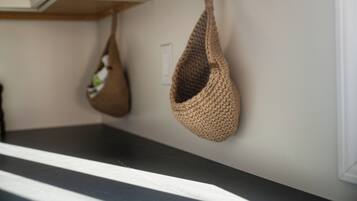 A kitchen with a black countertop and two hanging bags.