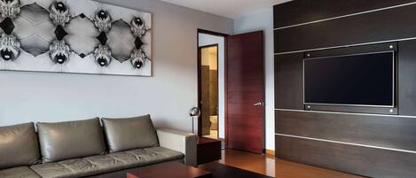 Una sala de estar moderna con un sofá modular, un televisor de pantalla plana montado en la pared y una decoración de estilo minimalista.