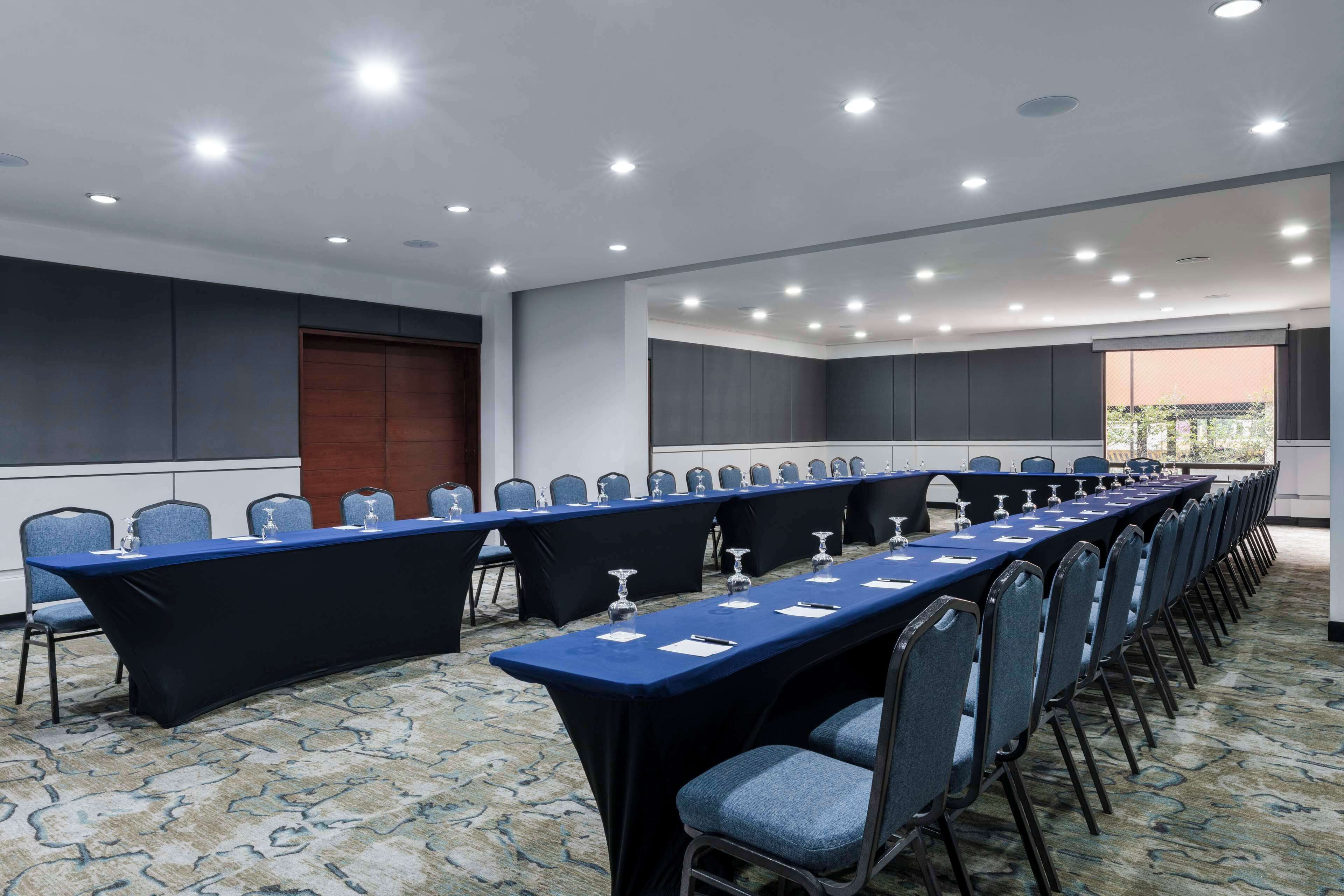 A conference room with a long table, chairs, and a view of the outdoors.