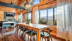 A spacious wooden interior with a dining area, large windows, and a view of the mountains. - Scenic Views•Hot Tub•Near Downtown (Gatlinburg)