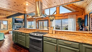 A modern kitchen with a large island, built-in oven, and a stainless steel range hood. - Scenic Views•Hot Tub•Near Downtown (Gatlinburg)