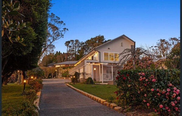 A two-story house with a driveway leading to the front door.