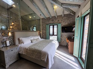 Un dormitorio con una cama grande, un aparador, un espejo y un televisor en la pared.