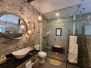 Ein modernes Badezimmer mit einem großen Spiegel, einem Waschbecken, einer Toilette und einer Duschkabine.