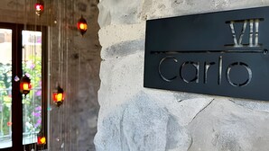A stone wall with a metal plaque reading "Villa Carlo".