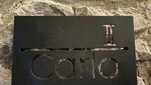 A black metal plaque with the inscription "I Carlo" on a stone surface. - Castello di Carlo – Loft Carlo II (Val'Quirico)