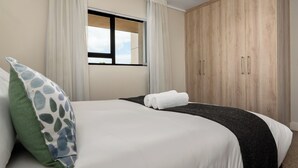 Ein Hotelzimmer mit Bett, Fenster und Kleiderschrank.